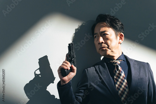 拳銃を持つミドル男性 photo