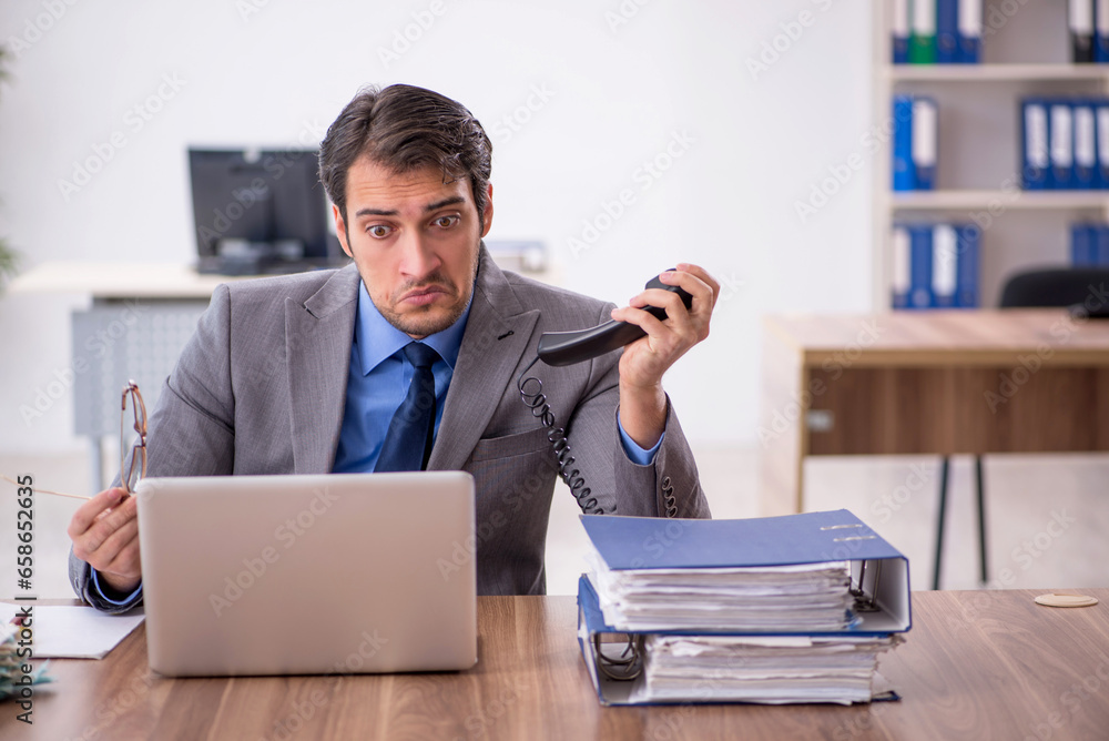 Young male employee talking by phone Young male employee talking by phone