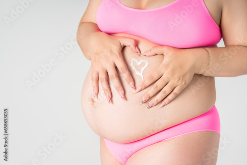 Wallpaper Mural Pregnant woman in pink underwear applying skin stretch mark cream on her belly on gray background, maternity underwear, pregnancy skin care concept Torontodigital.ca