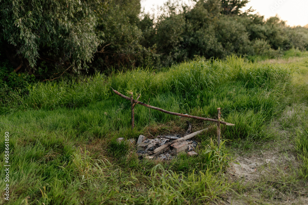 Campfire in nature. Fire among green grass. Relaxing in nature on a sunny summer day. Camping. Campfire in nature. Fire among green grass. Relaxing in nature on a sunny summer day. Camping.