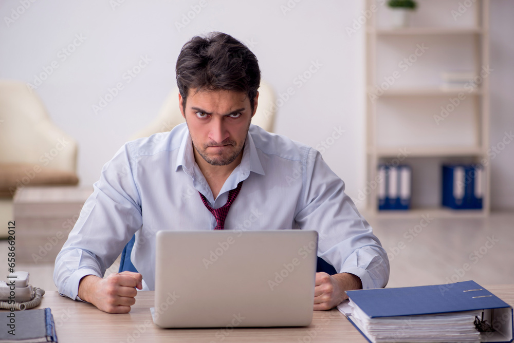 Young male employee working in the office Young male employee working in the office