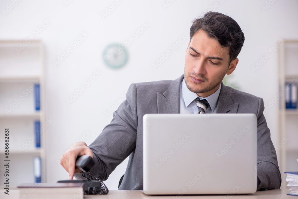 Young male employee working in the office Young male employee working in the office