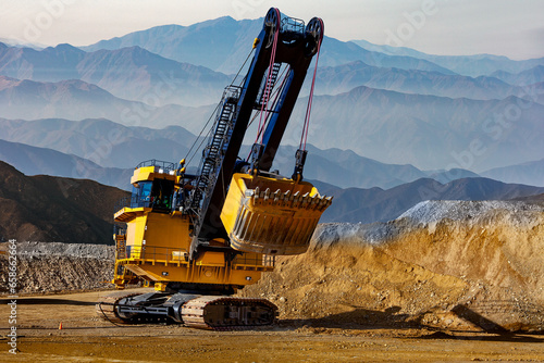 An electric rope shovel is a type of heavy mining equipment used in open-pit mining operations to excavate and load large quantities of material, such as overburden, ore, or waste rock. photo