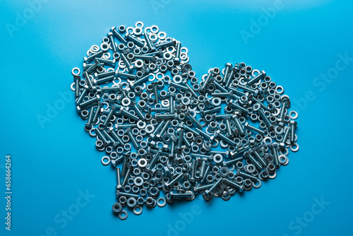 The metal heart is isolated on a blue background. The concept of cold bloodedness. Attachment material