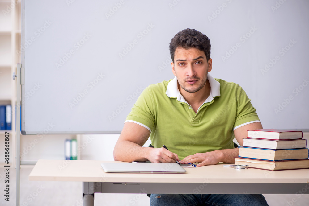 Young male student sitting in the classroom Young male student sitting in the classroom