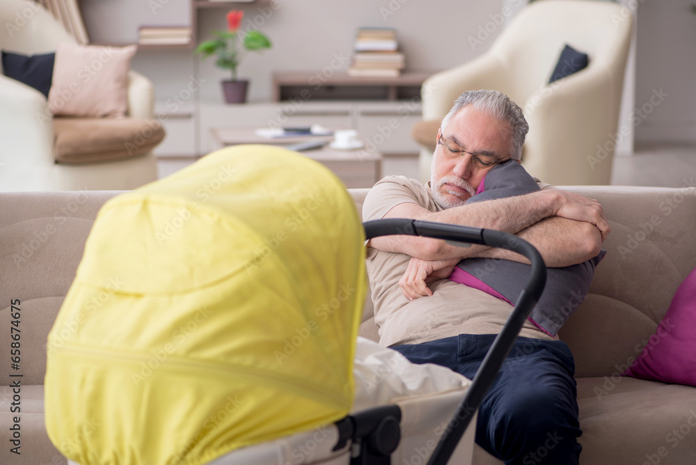 Old man looking after newborn at home Old man looking after newborn at home