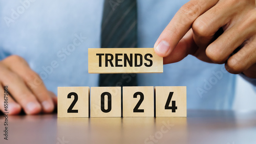 2024 trend concept.Businessman hand holding wooden block with 2024 trends word.Business development to success and growing growth concept.