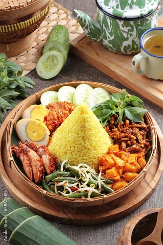 Tumpeng is an Indonesian cone-shaped rice dish with side dishes of vegetables and meat originating from Javanese cuisine of Indonesia. Traditionally featured in the slamatan ceremony. photo