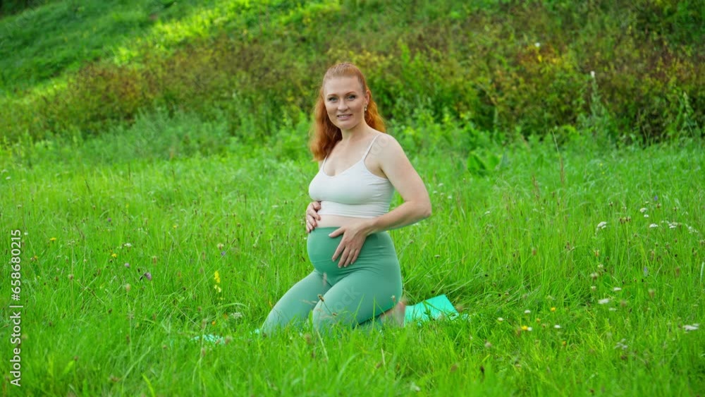 Young expecting mother holding baby in pregnant belly. Female stroking pregnant belly outdoors. Concept of mother and child health. Young expecting mother holding baby in pregnant belly. Female stroking pregnant belly outdoors. Concept of mother and child health.