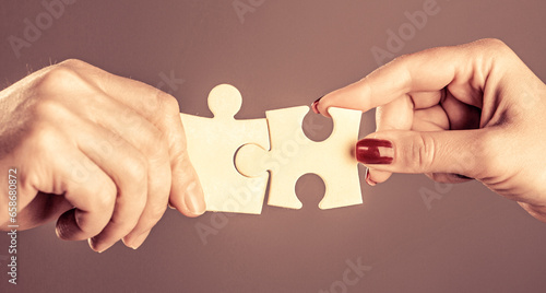 Puzzles. Hand of the child and hand of mother fold puzzle, closeup. Hands hold puzzles. Solution of problems. Mens and childs hands connecting puzzles