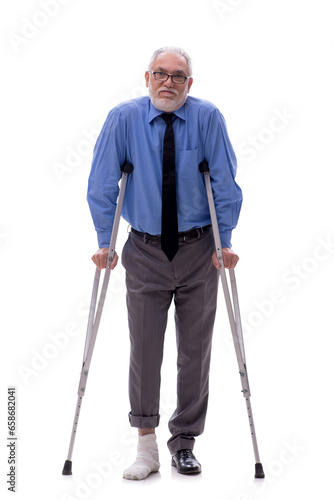 Old businessman with crutches isolated on white