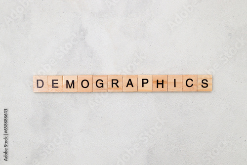 Top view of Demographics word on wooden cube letter block on white background. Business concept © Yazid Nasuha