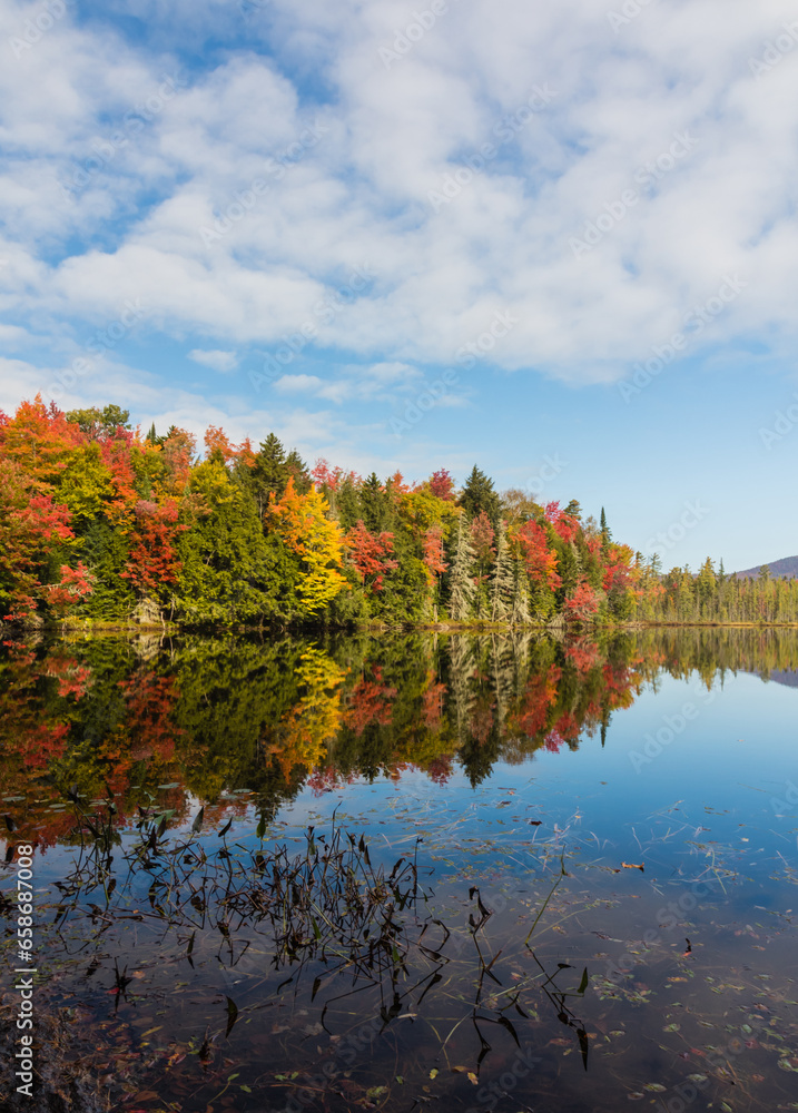 Adirondack lake in St Regis Wilderness with peak fall foliage on a peaceful calm morning Adirondack lake in St Regis Wilderness with peak fall foliage on a peaceful calm morning