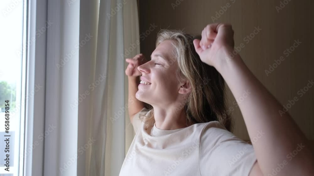 closeup of woman waking up and stretching in the morning in hotel room by the window closeup of woman waking up and stretching in the morning in hotel room by the window