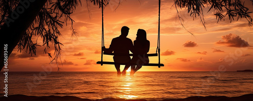 Romantic couple on swing in suset light on the beach.