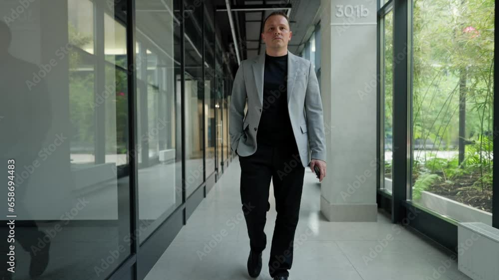 The boss in a business suit walks down the corridor The boss in a business suit walks down the corridor