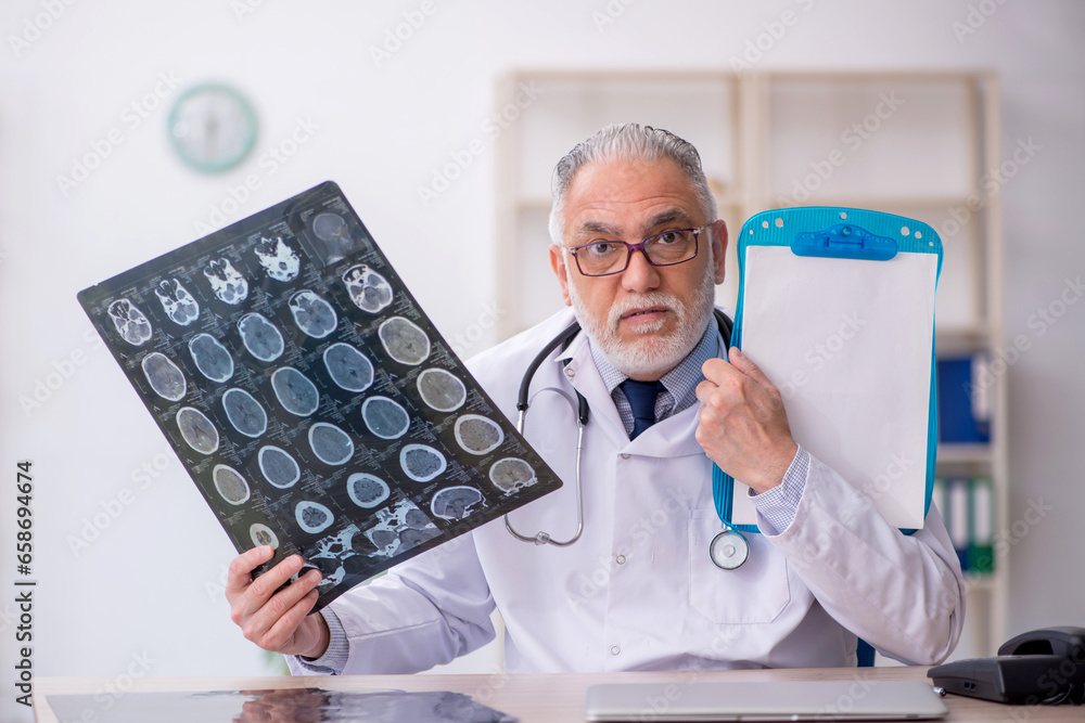 Old male doctor radiologist working in the clinic Old male doctor radiologist working in the clinic