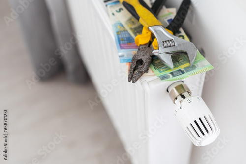 A stack of money on the background of the radiator. Expensive utilities.