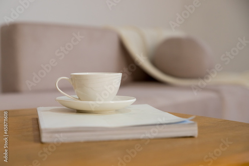 Work from home, renting apartment, buying. beige sofa with pillows, table with cup of hot drink, shelves in living room interior.Concept of morning cup of coffee, good start to the day, a cozy home.