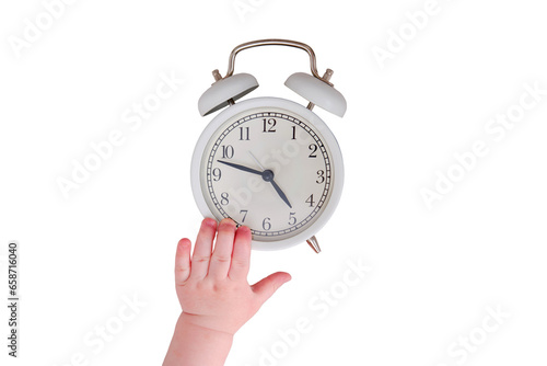 Baby toddler boy holds an alarm clock in his hand, isolated on a white background. Child with a white alarm clockt, close-up