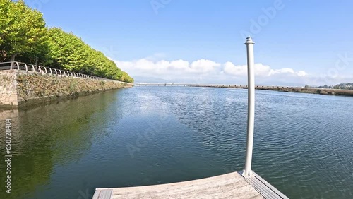 wooden pier on the Coura River with a view to the bridge in Caminha, Alto Minho Subregion, district of Viana do Castelo, Portugal photo