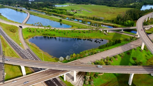 Aerial video nature beautification by highway interchange. View of palms lakes and green grass photo