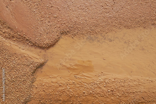 Close-up of earthy and muddy puddle on wet dirt road
