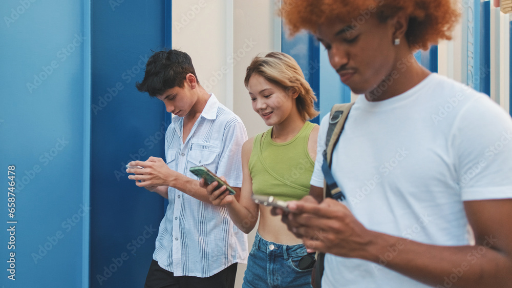 Fototapeta premium Three friends walking down the street holding mobile phones