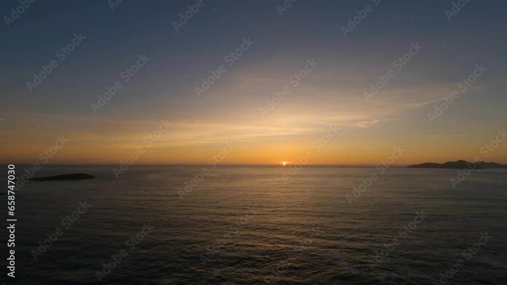 Mesmerizing timelapse of sunset from Monteferro's Compass Rose, with Cies and Estelas islands. Continuous sea motion, passing ships, and vibrant orange hues as the sun sets. Mesmerizing timelapse of sunset from Monteferro's Compass Rose, with Cies and Estelas islands. Continuous sea motion, passing ships, and vibrant orange hues as the sun sets.