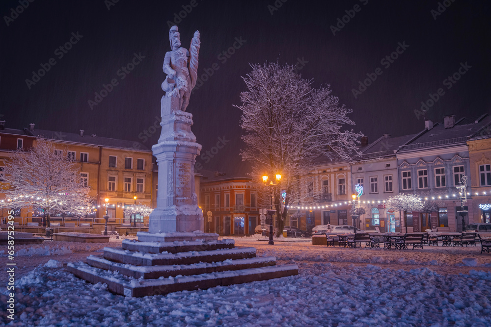 Pomnik Św. Floriana na rynku W Brzesku zimą w nocy | Monument of the St. Florian on the town square in Brzesko by winter by night - obrazy, fototapety, plakaty 