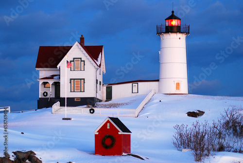 The Nubble light in Maine, New England is surrounded by an island of snow and decorated for the Christmas holiday. photo