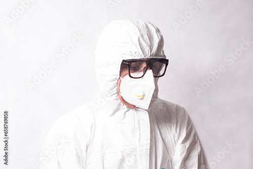 Doctor scientist in white coverall suit, mask and glasses. Dispersal and research of dangerous viruses and bacteria radiation concept. photo