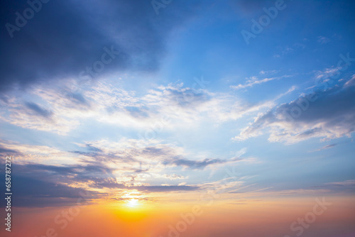  Sunrise with sun rays sunlight  in  clouds against bright blue sky © Vadim