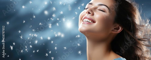happy smiling young girl on a blue winter background with snowflakes, banner with copy space