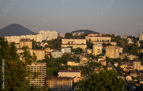 Sochi  Krasnodar Krai  Russia - August  7  2023  panoramic view of residential buildings among green hills in the city center at sunset and space for copying