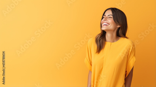 Confident mature woman with crossed arms in casual clothing with copy space. Successful smiling woman with big grin looking at camera. Beautiful positive businesswoman standing against yellow © PaulShlykov