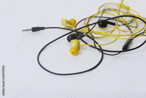 old headphones, tangled wires on white background.