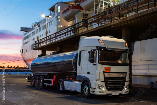 Fuel tank truck waiting next to a ferry to supply it. photo