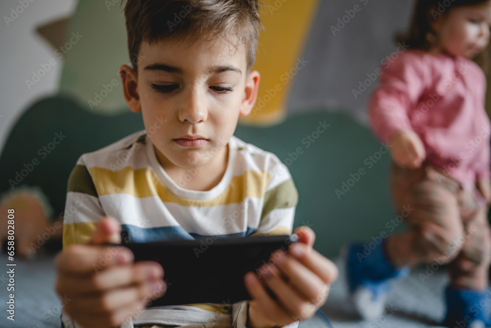 One caucasian boy child use smartphone mobile phone at home play games One caucasian boy child use smartphone mobile phone at home play games