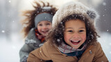 Happy children playing outside in the snow during cold freezing snowy winter season