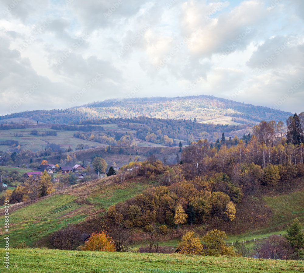 Fototapeta premium Cloudy and foggy autumn mountain countryside scene. Carpathians, Ukraine. Peaceful picturesque traveling, seasonal, nature and countryside beauty concept scene.