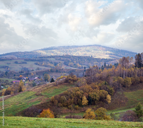 Cloudy and foggy autumn mountain countryside scene. Carpathians, Ukraine. Peaceful picturesque traveling, seasonal, nature and countryside beauty concept scene.
