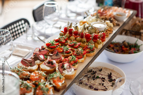 Canapes of mozzarella, green olives, cherry tomatoes, assorted cheeses on a banquet.