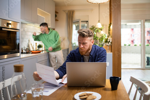 Young Caucasian man going over bills and payments at home photo