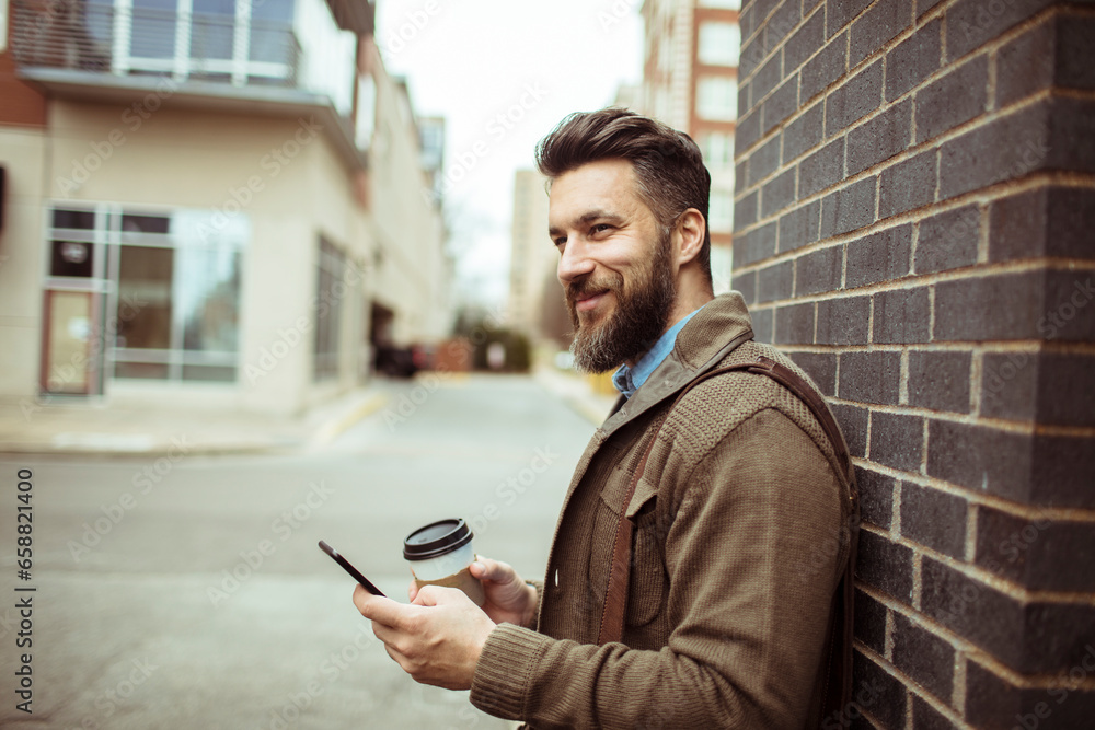Young man using his smartphone while commuting to work on foot Young man using his smartphone while commuting to work on foot