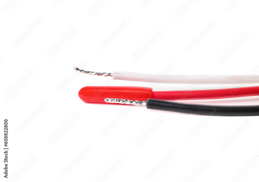 Isolated electrical wires. Close up of red, black and neutral wires indicating hot wire, secondary and neutral charge. Cables for hard wired smoke detector. Selective focus. White background. Isolated electrical wires. Close up of red, black and neutral wires indicating hot wire, secondary and neutral charge. Cables for hard wired smoke detector. Selective focus. White background.