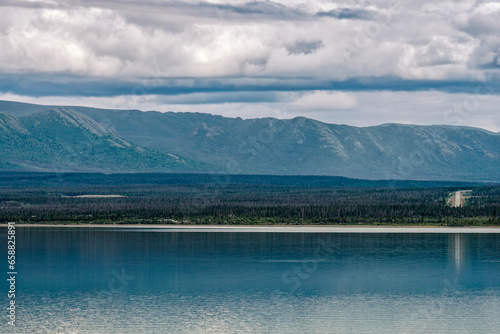 The Alaska Highway is visible across the waters of Kluane Lake in the Yukon Territory, Canada