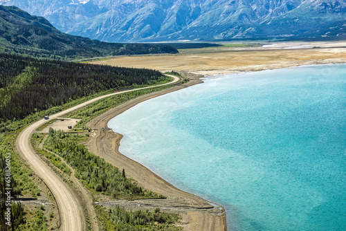 An aerial view of the Alaska Highway curving along Kluane Lake in the Yukon Territory, Canada