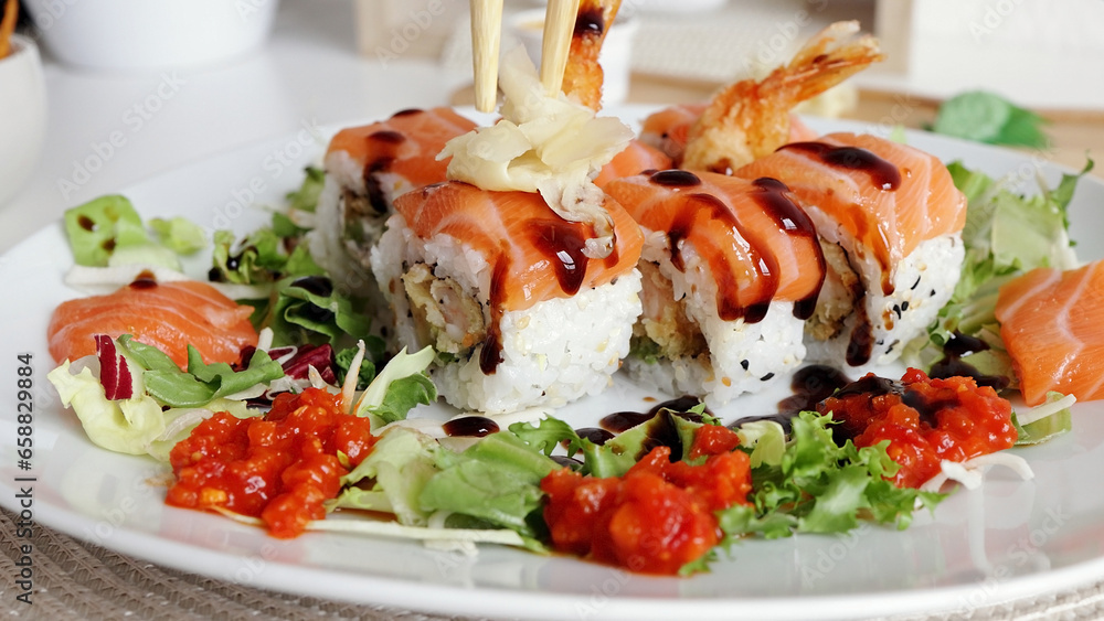 Traditional Japanese food. close-up. Sushi decorated with teriyaki sauce. Freshly cooked sushi rolls, served on a white plate at home Traditional Japanese food. close-up. Sushi decorated with teriyaki sauce. Freshly cooked sushi rolls, served on a white plate at home