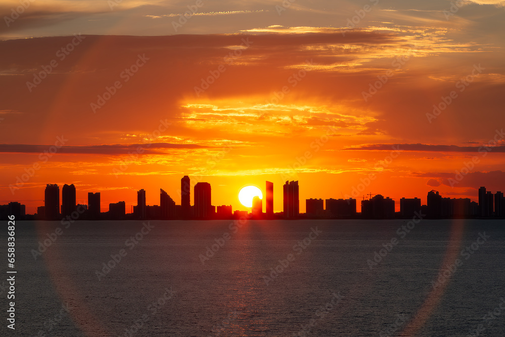 The sunset behind buildings on the Atlantic coastline in southern Florida
